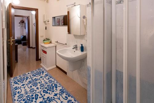 bagno bianco con lavandino e doccia di Pied à terre – Atelier a Verona