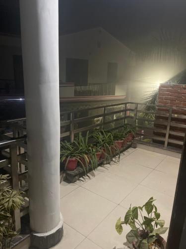 una habitación con una columna y plantas en un balcón en Shiv mahima nivas, en Bareilly