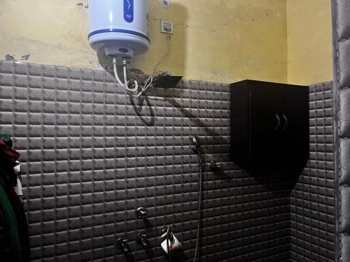 y baño con ducha y pared de azulejos negros. en Shiv mahima nivas, en Bareilly