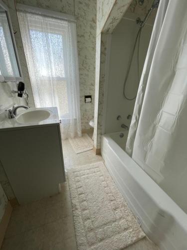 a bathroom with a tub and a sink and a bath tub at 3 Bed House in Niagara Falls in Niagara Falls