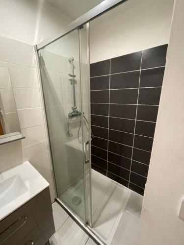 a shower with a glass door in a bathroom at Le 90'S in Tulle