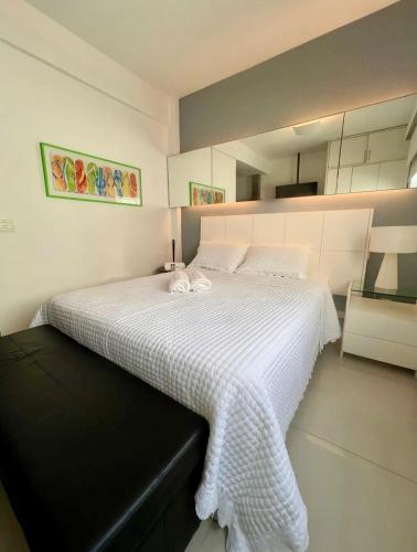 1 dormitorio con 1 cama grande y edredón blanco en Apartamento Studio Deluxe HIR 37, en Río de Janeiro