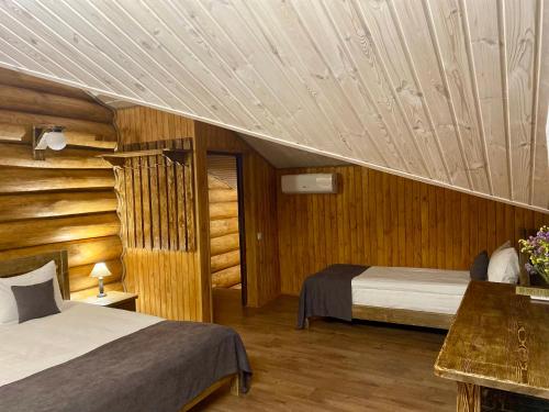 a bedroom with two beds and a wooden ceiling at Resort Stariy Prud in Filippovichi