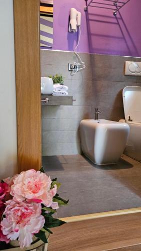 bagno con lavandino, servizi igienici e fiori di Select Executive Residence a Firenze