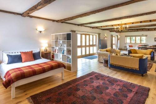 a bedroom with a bed and a living room at The Granary - Wood Farm Barn. Luxury Barn with wonderful countryside views in Bawdeswell