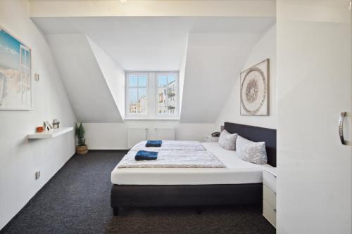 um quarto com uma cama grande num quarto branco em home2stay Apartmenthaus Dresden em Dresden