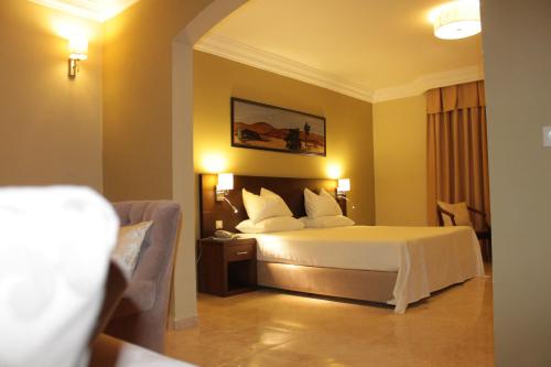 a hotel room with a bed and a couch at Hotel Mauricenter Nouakchott in Nouakchott