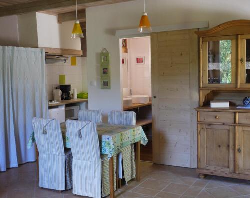 une cuisine avec une table et des chaises dans une cuisine dans l'établissement Les Jardins de Lumière, à Brusque