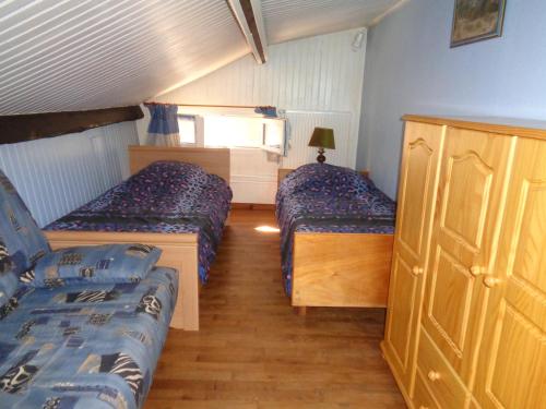 um quarto com duas camas e um armário em Au Pied du Cognelot em Chalindrey
