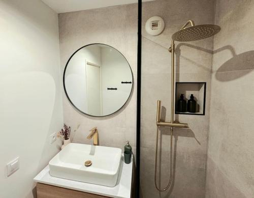 y baño con lavabo y espejo. en New Disneyland Paris Serena Apartment, en Bussy-Saint-Georges