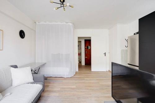un salon blanc avec un canapé et une table dans l'établissement Appartement refait à neuf - Paris, à Paris