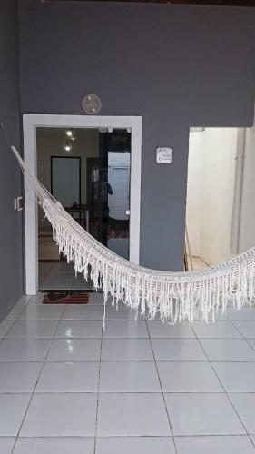 a white hammock in a room with a tile floor at Casa MD in Camocim