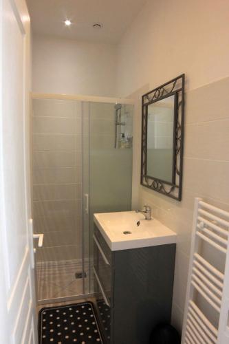 une salle de bain avec un lavabo et une douche avec un miroir dans l'établissement Maison hôtes près de Disneyland Paris, à Lagny-sur-Marne