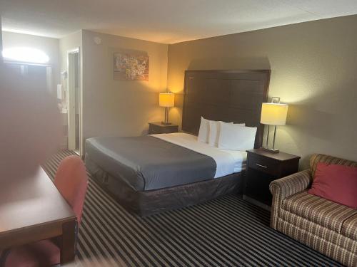 a hotel room with a bed and a couch at Econo Lodge Florence - Darlington in Florence
