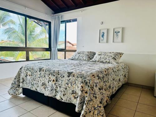a bedroom with a bed and a large window at Bangalô Boutique com piscina Privativa - 3 Suítes in Porto De Galinhas