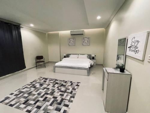 1 dormitorio con cama, mesa y alfombra en One bedroom, pool, self entry en Yeda