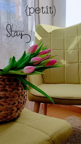a basket of pink tulips sitting next to a chair at Hotel Petit in Silvi Marina