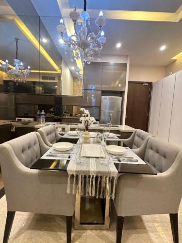 uma cozinha com uma mesa com cadeiras e uma sala de jantar em Dorsett Suites City Center KL em Kuala Lumpur