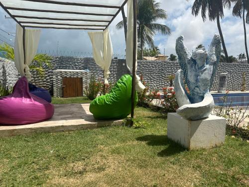 una estatua de un ángel sentado junto a dos esferas inflables en Relais de Charme Boutique Hotel Pititinga, en Rio do Fogo