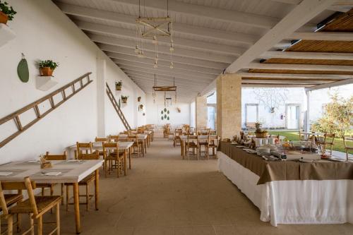a dining room with tables and chairs in a building at Masseria Rauccio in Torre dell'Orso