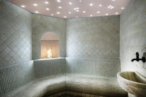 a bathroom with a tub and a sink at Hotel Arcobaleno in Fai della Paganella