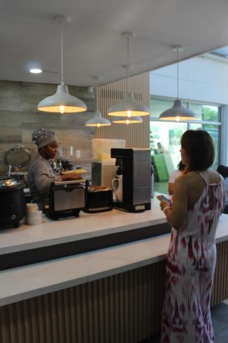 a woman standing in front of a counter in a restaurant at Hotel Genova Prado in Barranquilla