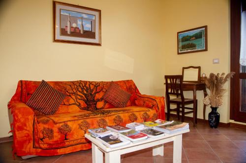 a living room with a couch and a table with books at Casa vacanze Trasimeno in Sant Arcangelo