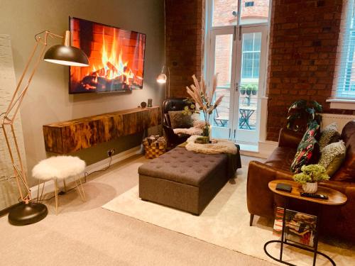 uma sala de estar com um sofá e uma lareira em The Fifth Quarters, Grade II Listed Apartment, The Lace Market, NG1, City Centre, Nottingham, Sleeps 4 em Nottingham