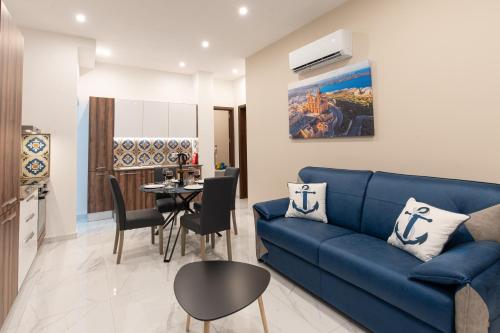 un soggiorno con un divano blu e un tavolo di Aloha - Village Apartment 2 BR in Mellieha a Mellieħa