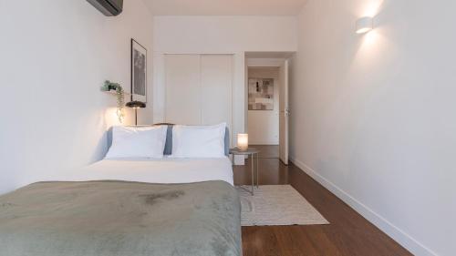 een witte slaapkamer met een bed met witte kussens bij Classy 3BDR Property by LovelyStay in Lissabon