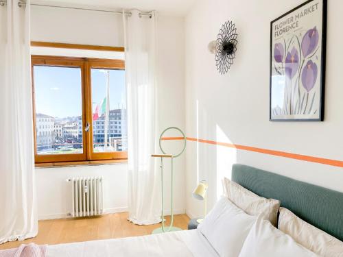 Schlafzimmer mit einem Bett und einem Fenster in der Unterkunft Alinari Boutique Apartments in Florenz