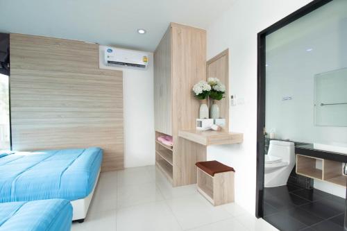 a bedroom with a blue bed and a bathroom at 94 Pool Villa in Ban Huai Yai