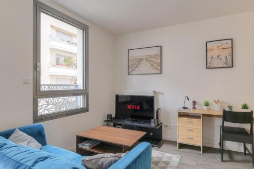 - un salon avec un canapé bleu et un bureau dans l'établissement Expérience 3D Flat, à Villeurbanne