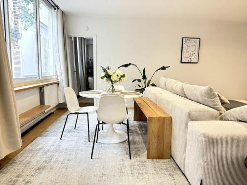un salon avec un canapé, une table et des chaises dans l'établissement Acogedor apartamento en el centro de París., à Paris