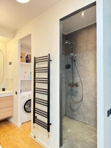 une salle de bain avec douche et machine à laver dans l'établissement Acogedor apartamento en el centro de París., à Paris