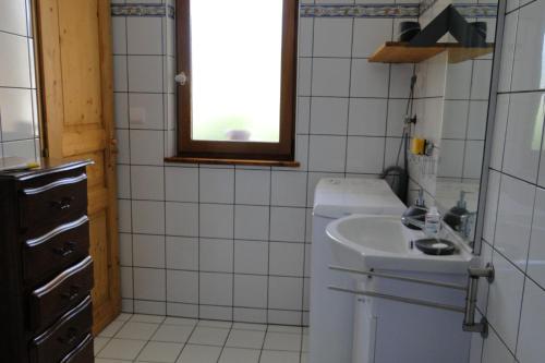 una piccola cucina bianca con lavandino e finestra di Gite le Pré de Lamia a Chevenoz