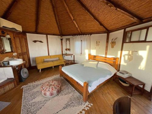 a bedroom with a bed and a couch in a room at Best View Romantic Cabin In Eco Village Klil in Clil