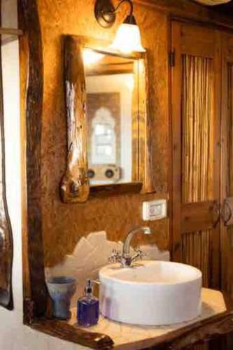 a bathroom with a sink and a mirror at Best View Romantic Cabin In Eco Village Klil in Clil