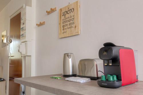 - une cafetière rouge et noire sur un comptoir de cuisine dans l'établissement Élégant et Spacieux idéal déplacement Pro, à Sainte-Foy-lès-Lyon