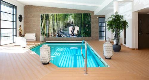 a swimming pool in a house with a painting on the wall at Résidence Service Seniors MONTANA in Avignon