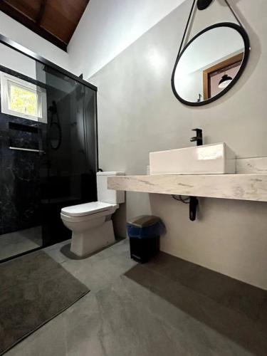 ein Badezimmer mit einem Waschbecken, einem WC und einem Spiegel in der Unterkunft Casa Meninas do Rio 01 in Lençóis