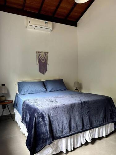 ein Schlafzimmer mit einem blauen Bett in einem weißen Zimmer in der Unterkunft Casa Meninas do Rio 01 in Lençóis