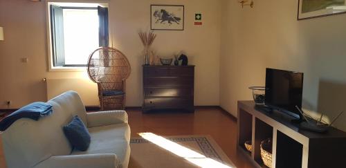 a living room with a couch and a television at Palácio da Portela III in Coimbra