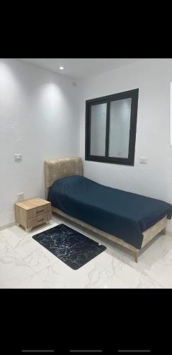 1 dormitorio con cama y ventana. en Sousse home, en Hammam Sousse