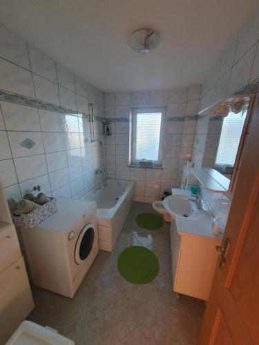 a bathroom with a tub sink and a washing machine at Mia in Tomislavgrad