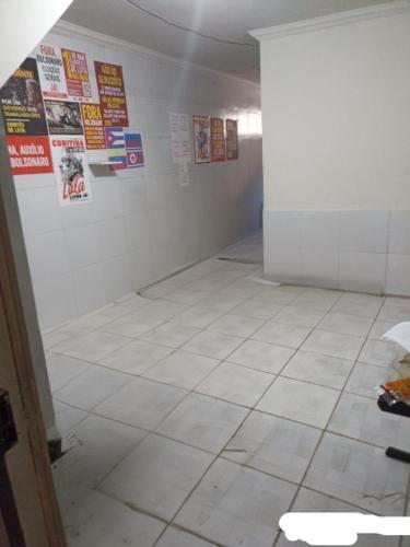 a room with a white tiled floor and posters on the wall at CASA CARNAVAL OLINDA- 700M PREFEITURA in Olinda