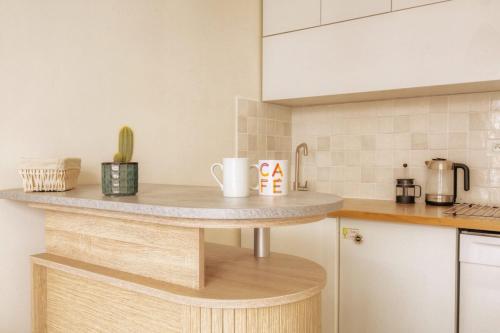 a kitchen with a counter with two mugs on it at Le calme et cosy avec parking gratuit in Lyon