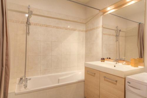 une salle de bain avec une baignoire, un lavabo et une douche dans l'établissement Le calme et cosy avec parking gratuit, à Lyon