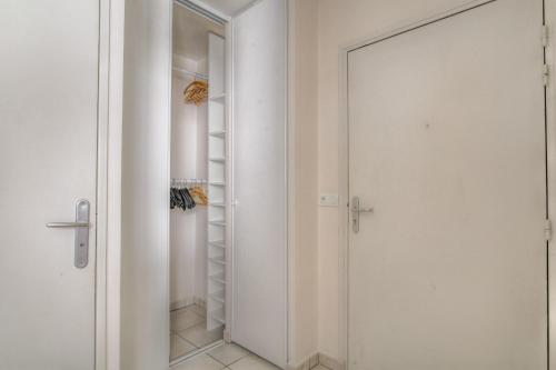 - un placard avec une porte en verre et un miroir dans l'établissement Le calme et cosy avec parking gratuit, à Lyon