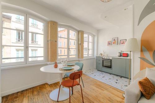 a kitchen and living room with a table and chairs at Design et cosy en hypercentre in Lyon